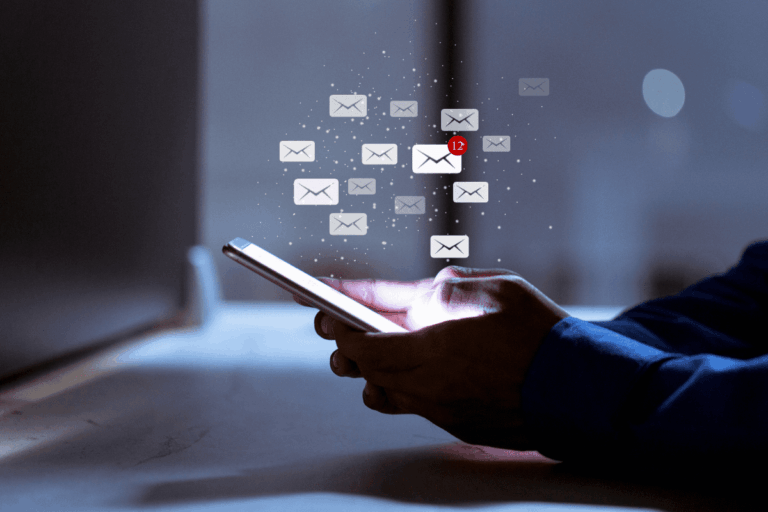 homem mexe no celular enquanto vários ícones de envelope de e-mail aparecem na ilustração da foto que destaca artigo sobre tendências de comunicação em e-mails corporativos